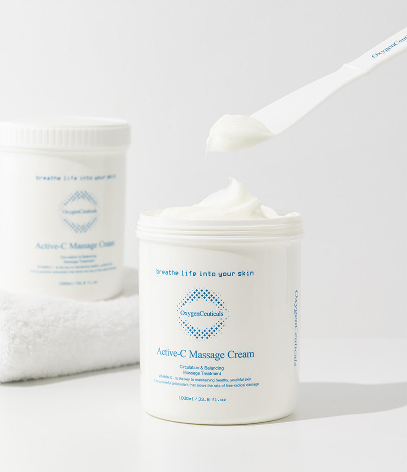 Skincare professional using a spatula to collect Active-C Massage Cream, a favored Vitamin Massage Cream in spas.