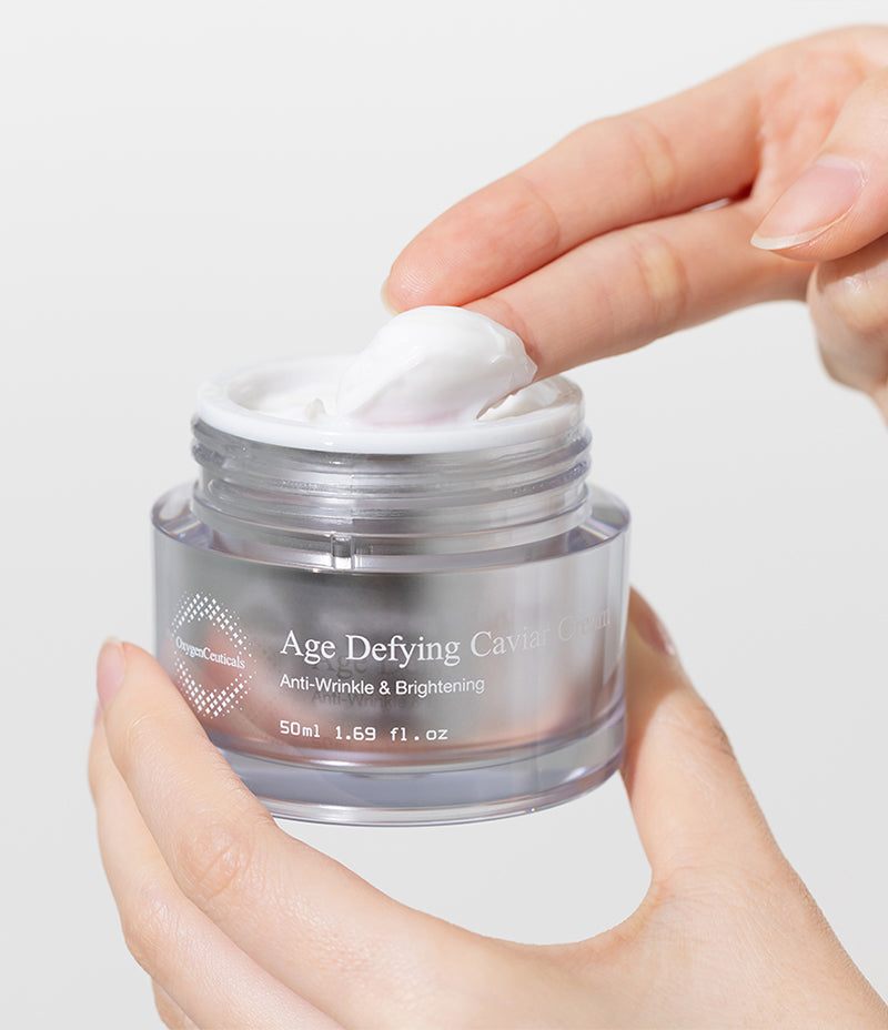 A hand holding a jar of Age Defying Caviar Cream, a luxurious cream for youthful skin.