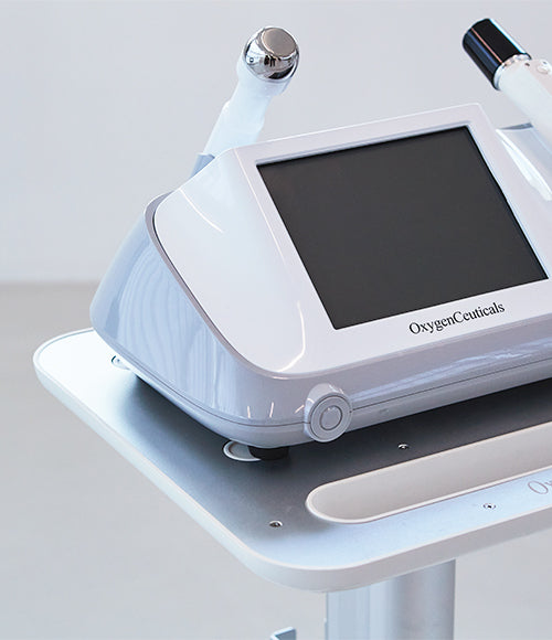A device with a monitor is placed on a table, showcasing OxygenCeuticals' HiFULDM technology.