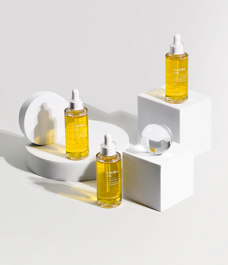 Moisturizing Jojoba Oil bottles showcased on white backdrop to lock in moisture on your skin. golden jojoba oil face oil, hobo oil, ojoba oil, jojoba oil and wrinkles, jujube oil.