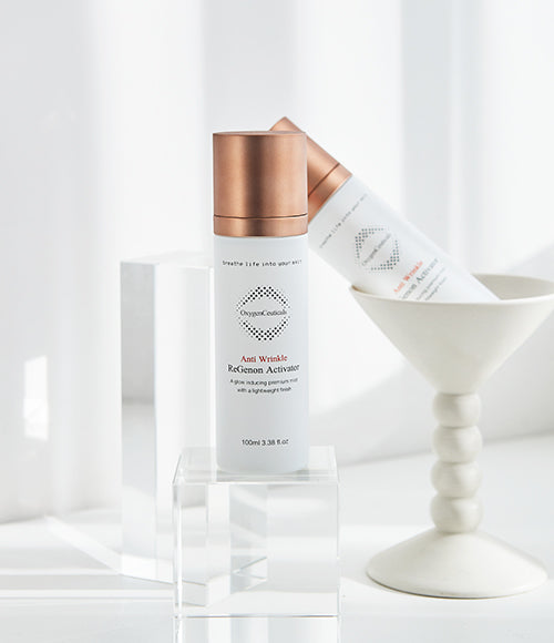 Two bottles of ReGenon Activator, a premium anti-aging ampoule mist, placed on a white table.