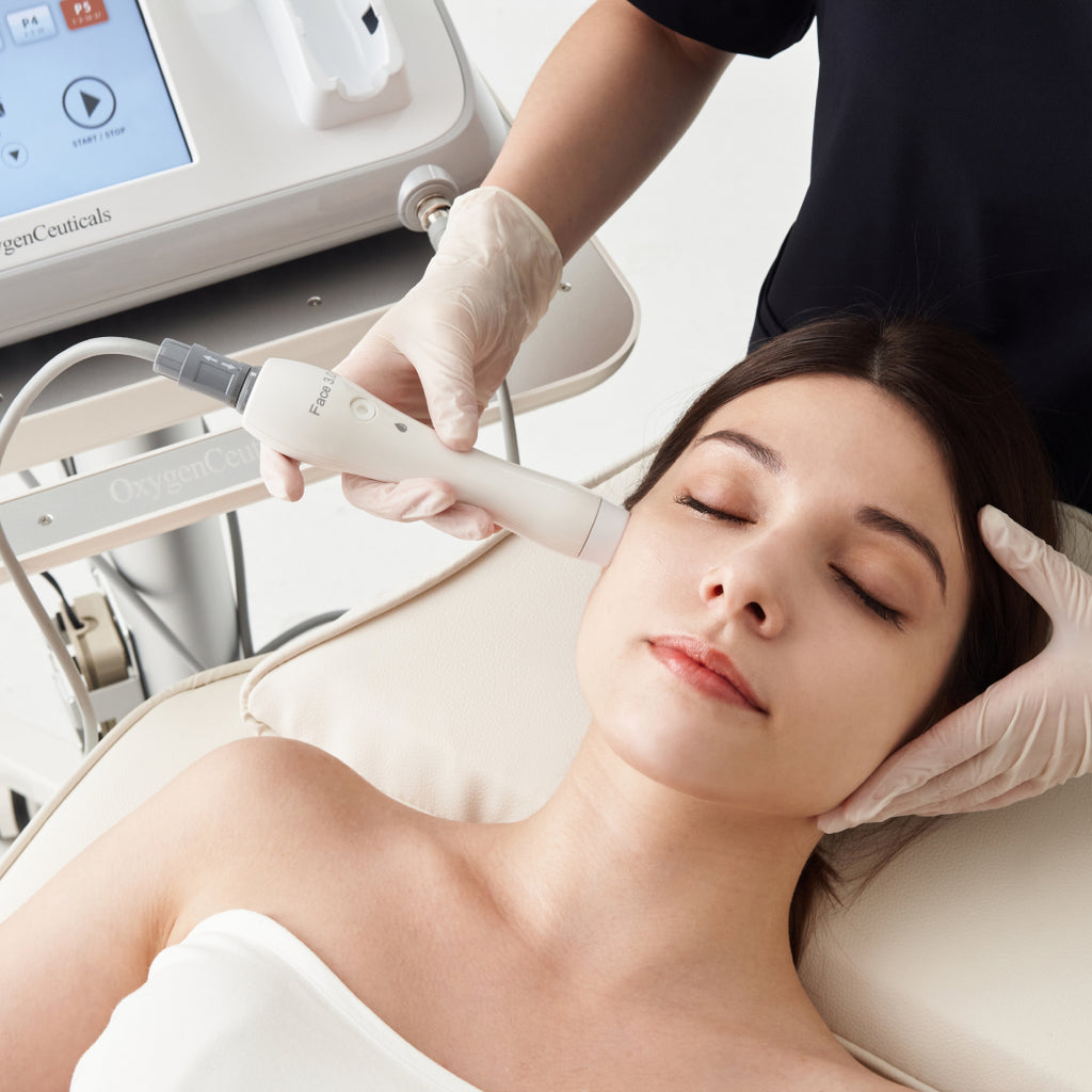  Woman experiencing an advanced ultrasonic facial lifting treatment with the innovative OxygenCeuticals HiFULDM hiFU wand.