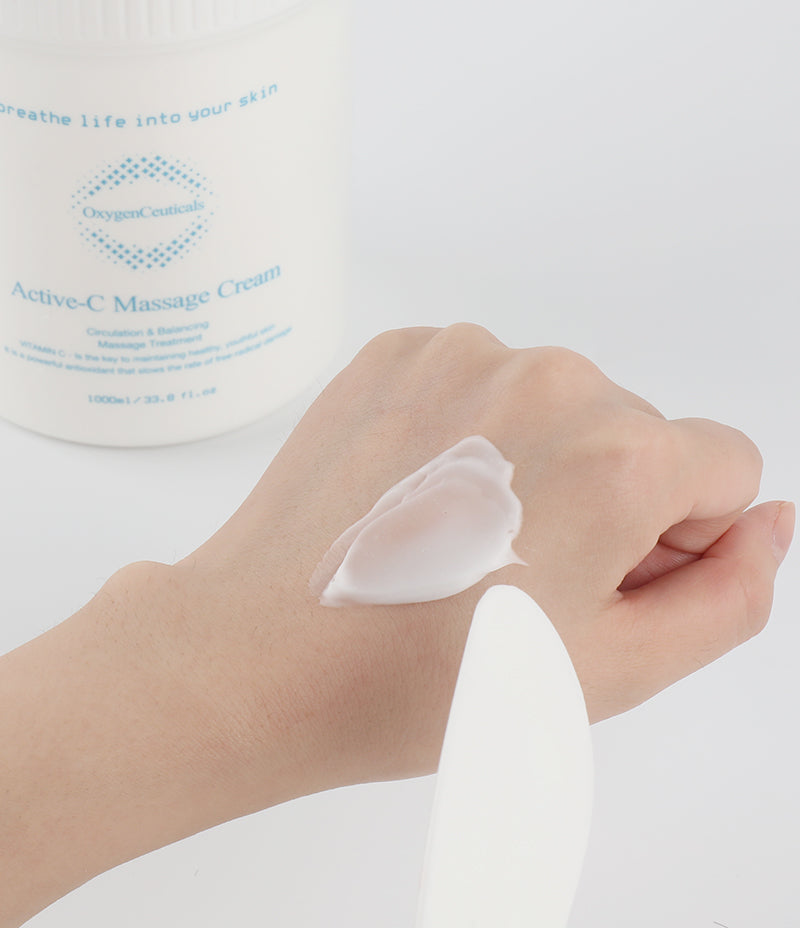 Hand demonstration of using brightening and smoothing Active-C Massage Cream for skincare.