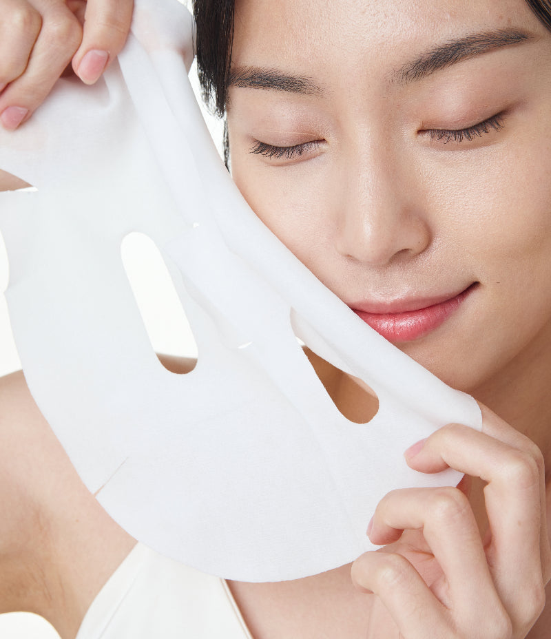 Satisfaction visible on a model's face as she uses the AG Mask, showcasing its skin brightening benefits.