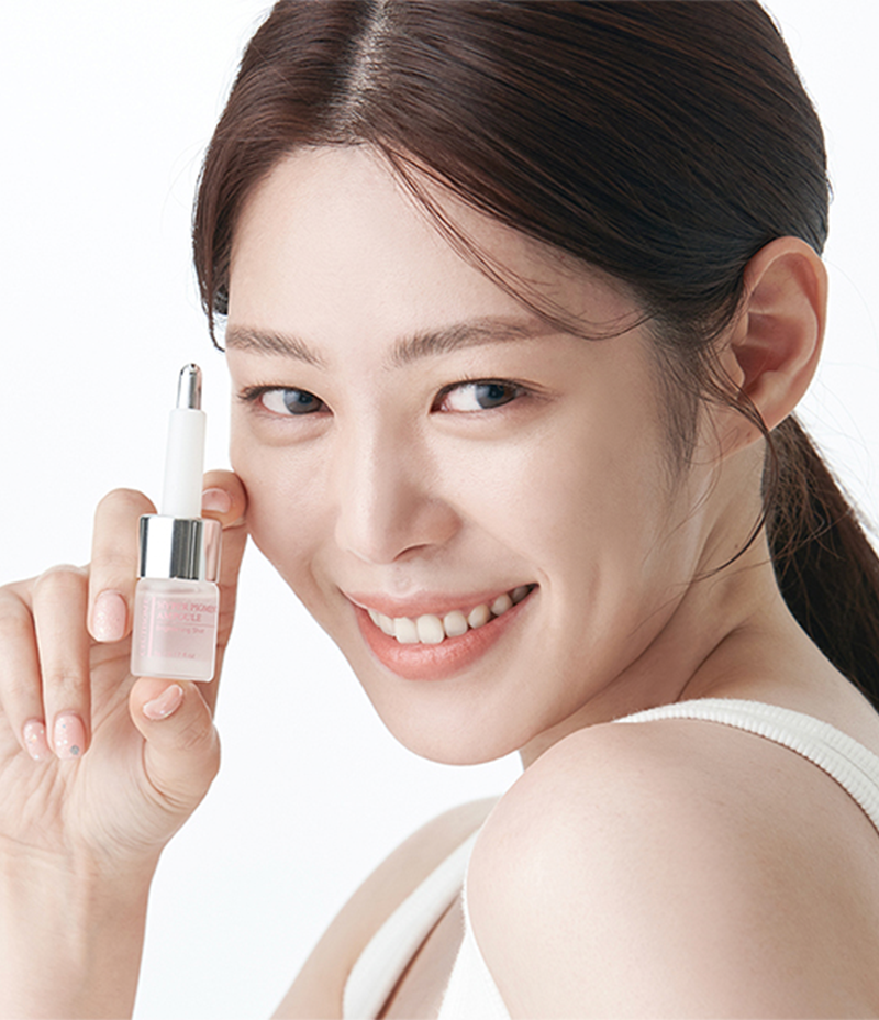 Smiling model with a product for treating hyperpigmentation, the Ceutisome Hyper Pigment Ampoule.