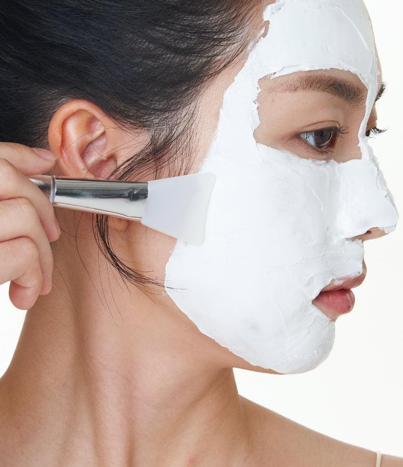  Gentle exfoliating process with a model using a Clarifying Mask and a silicone brush for skin care.