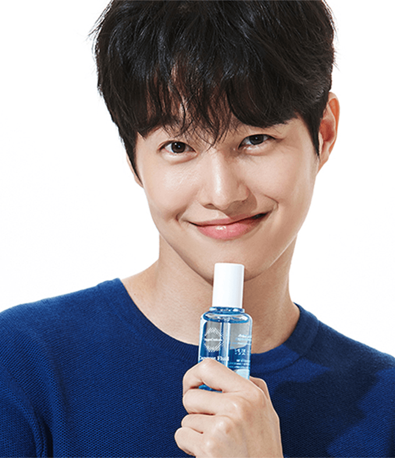 Korean male model confidently presenting a bottle of Couperose Fluid, a product designed to soothe inflammation.