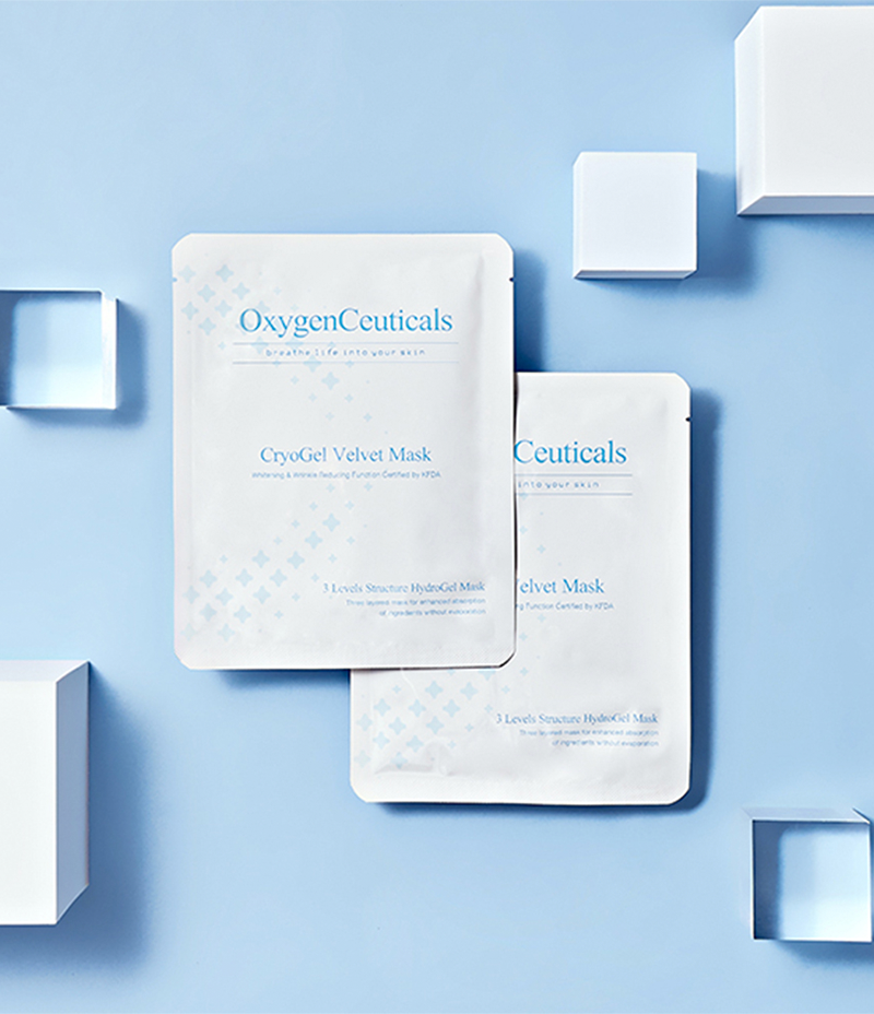 A package of Cryogel Velvet Mask for dry skin care, lying next to decorative glass cubes on a laboratory table