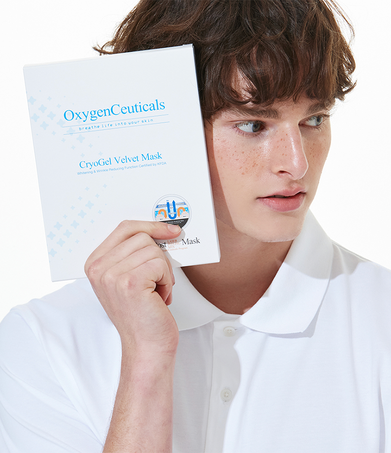  model presenting a box of triple gel layer Cryogel Velvet Masks while gazing to his left.