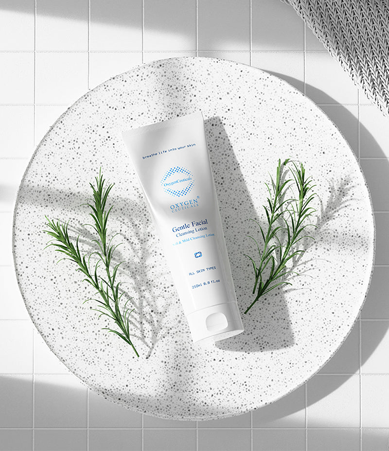 A plate holding OxygenCeuticals' Gentle Facial Cleansing Lotion tube, complemented by a sprig of rosemary.