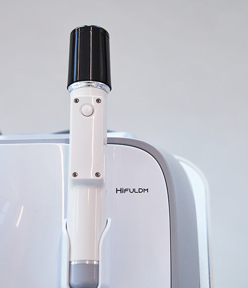 A close-up of the OxygenCeuticals HiFULDM handpiece, a white and black object used for ultrasonic skin treatments