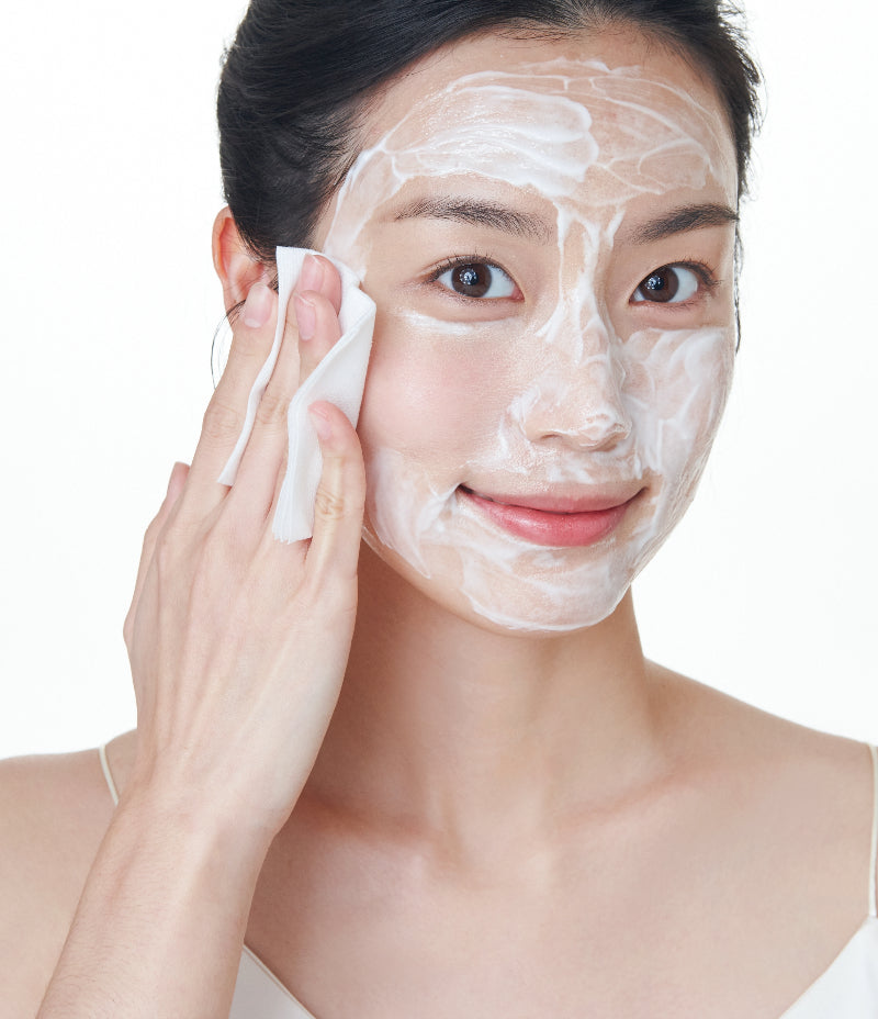 Woman wiping off the Gentle Facial Cleansing Lotion with a wet cotton pad.