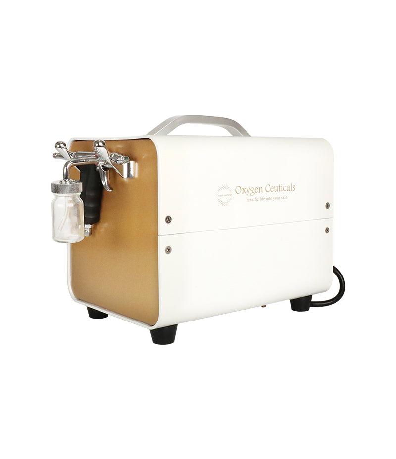 A compact white and gold portable air compressor, the OxygenCeuticals OZ Portable, designed for convenient oxygen therapy on the go.  Used for Oxygen facial. Can be used with masker oxygen, oxygen mask, oxygen serum, oxygen skincare, what is a misting device used for facial treatments, image oxygen facial.