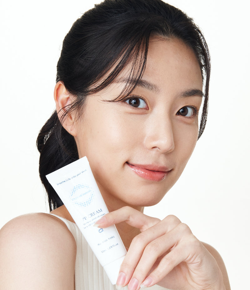 Smiling Korean model showcasing a peptide and adenosine infused PP Cream.