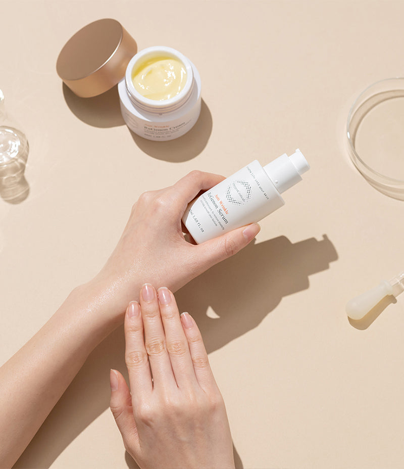 A woman's hands delicately hold a bottle of ReGenon Serum, a brightening antioxidant skincare product enriched with Idebenone for age-preventative benefits.