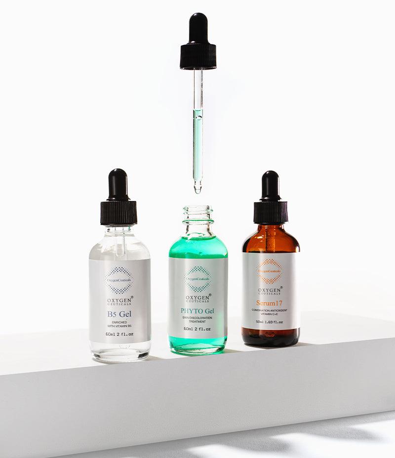 Three bottles of the Vitamin Serum Trio stand on a white surface with emphasis on the Phyto Gel. 