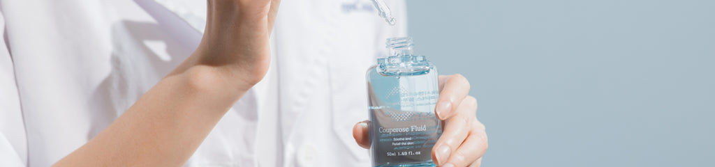  Healthcare professional showcasing the Couperose Fluid for redness relief, enriched with hydrolyzed collagen and aloe vera.