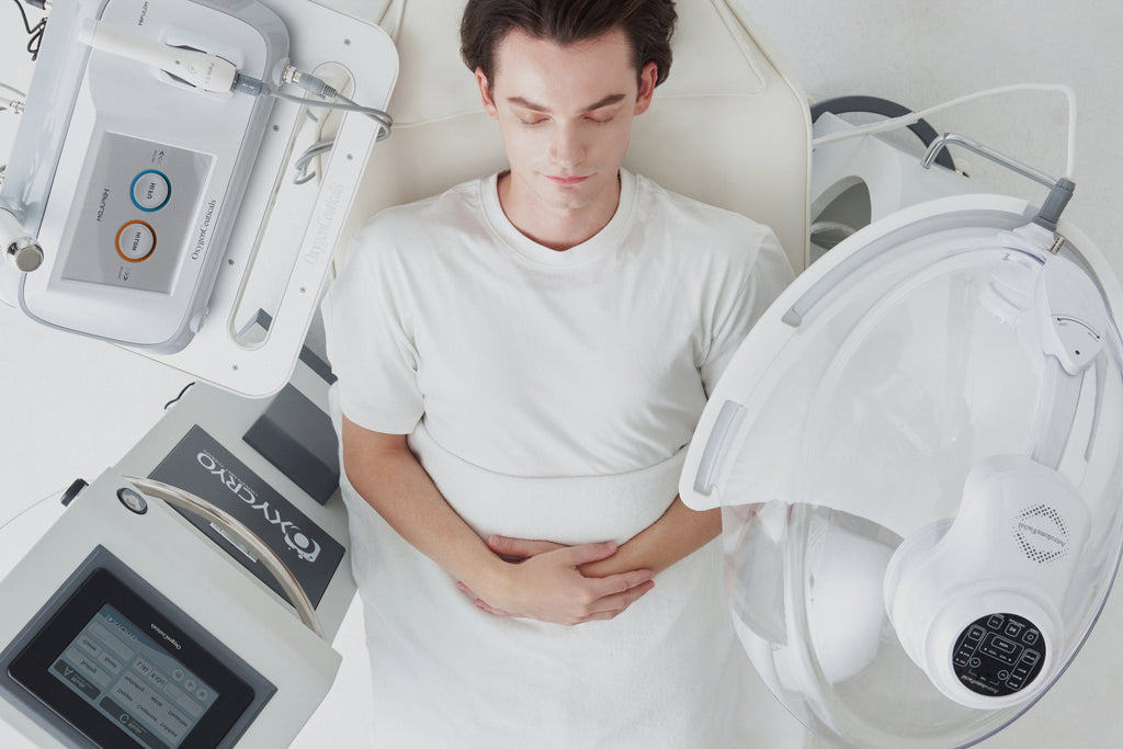 Man surrounded by OxygenCeuticals patented oxygen therapy advanced technology, the HiFULDM, AstrodomeFacial, and OxyCryo.