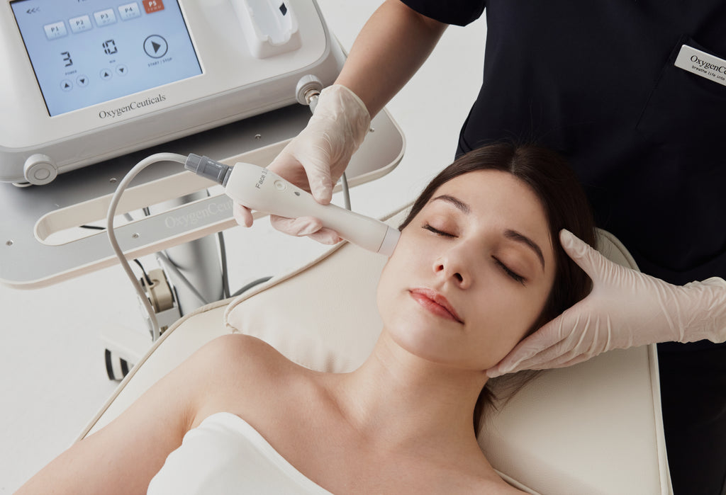 Woman receiving waterful skin lifting treatment with OxygenCeuticals' advanced ultrasonic HiFULDM technology.
