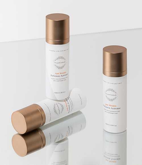 Three bottles of ReGenon Activator standing on a reflective white surface.